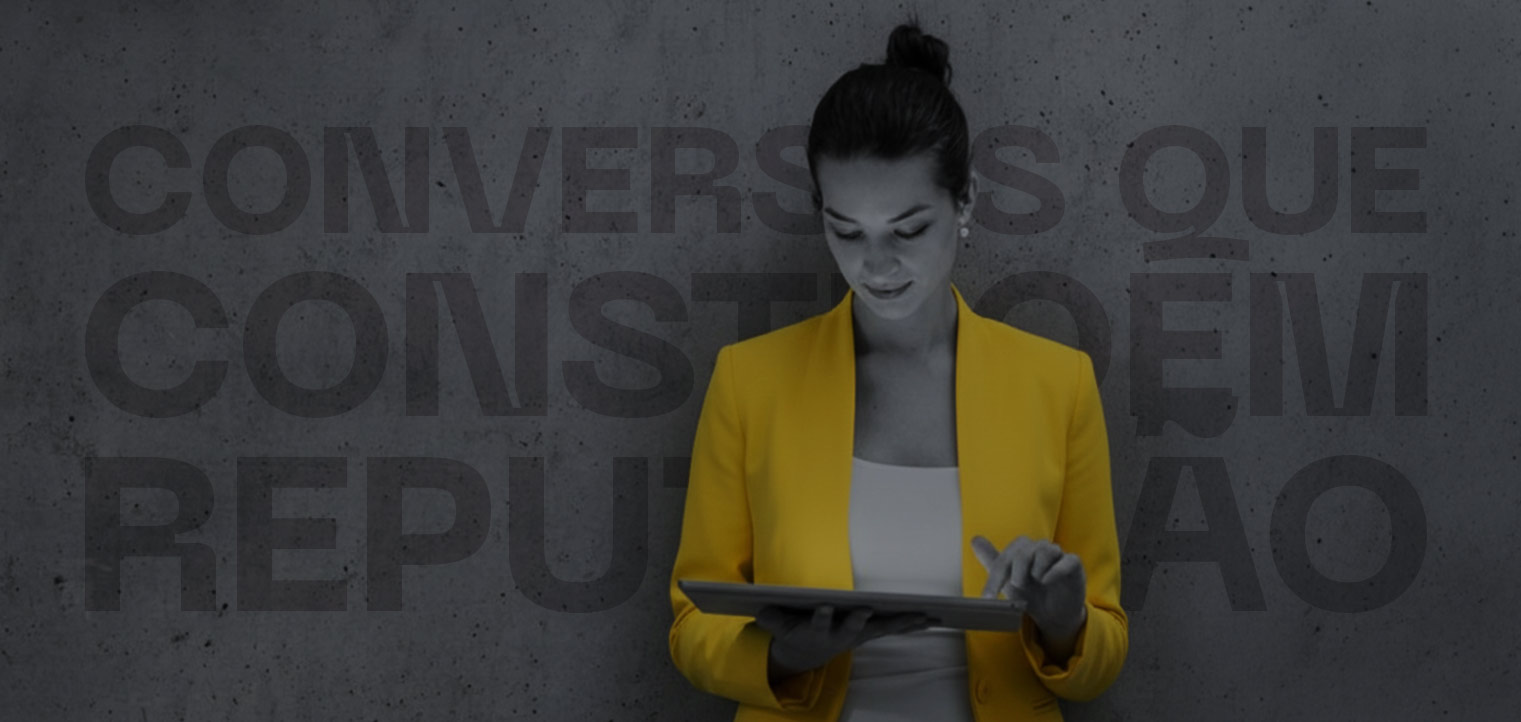 Mulher vestindo blazer amarelo e utilizando um tablet, sobre fundo cinza escuro, ao lado do texto “Conversas que constroem reputação”.
